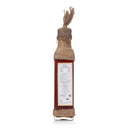 Bottle of sauce with a label and twine wrapping on a white background
