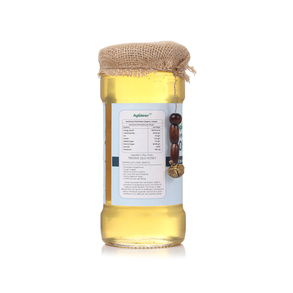 Jar of honey with a label and burlap lid on a white background